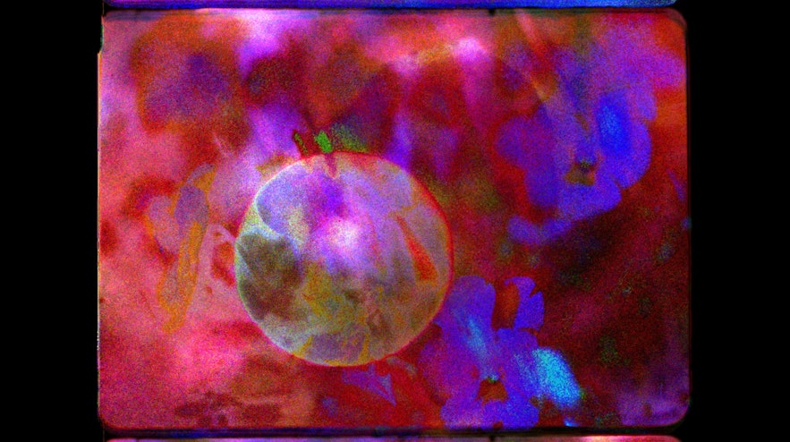 Abstract layers of violet flowers, deep red and a glowing circle in the middle.