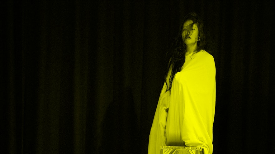 Person in a white sheet standing on a step ladder