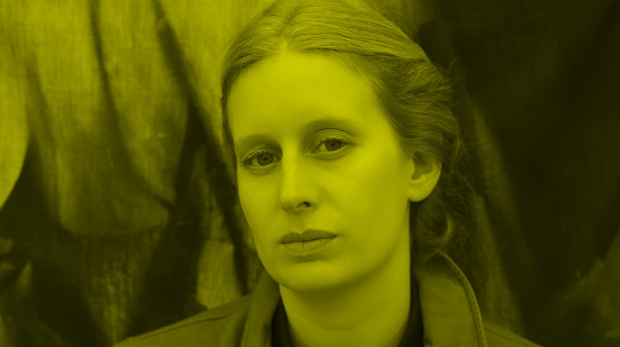 A person with light skin and light brown hair looks into the camera.