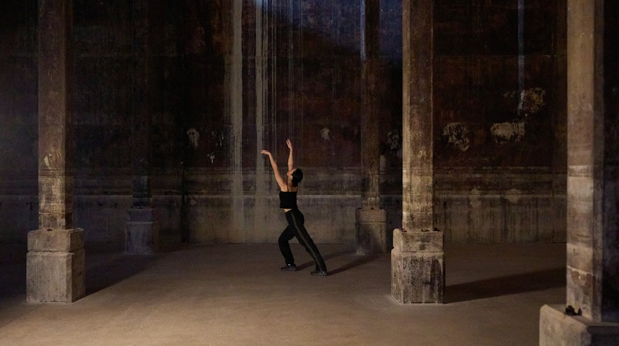 A person stretching their arms upwards in a former World War 2 oil tank space